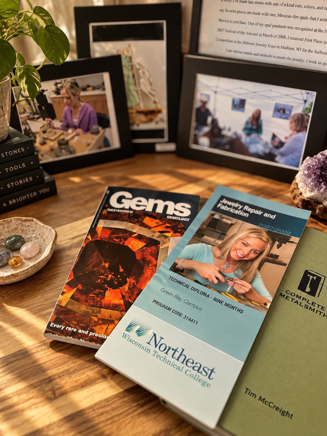 A flatlay of the jewelry school brochure, gem books, and old show photos
